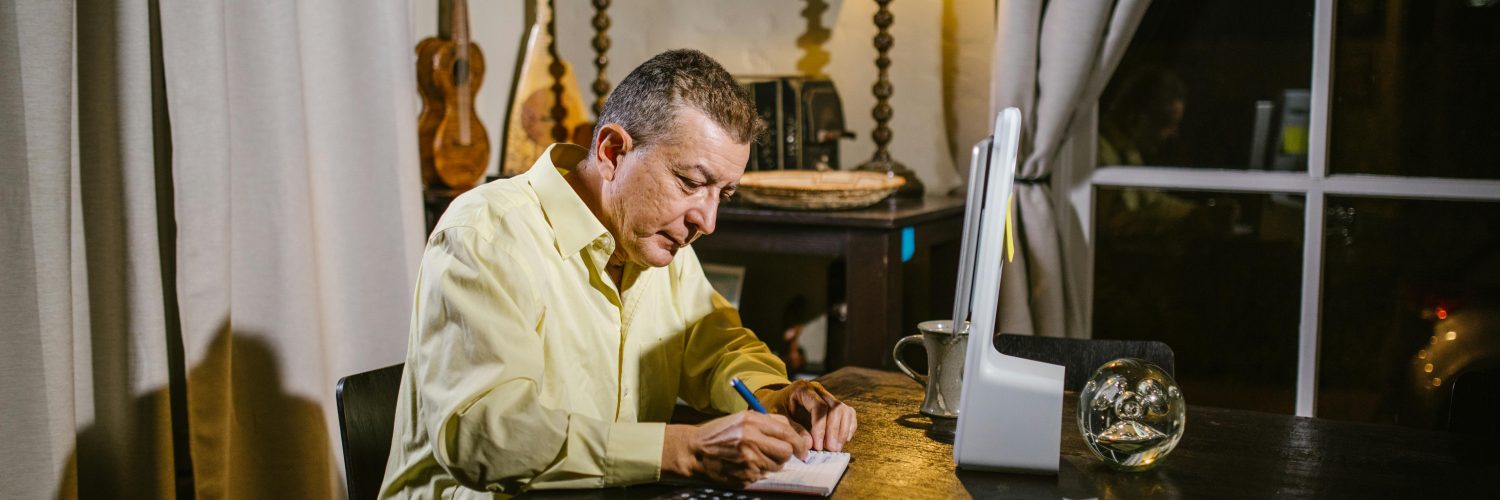 Therapist writing notes in soft evening light, symbolising the unseen effort and time that manual documentation requires