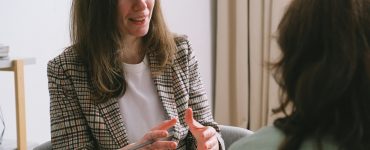 Therapist talking with a client in a calm office.